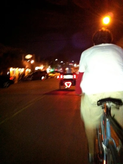 man riding his bike through a city at night
