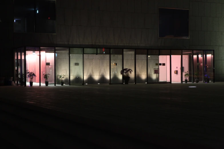 three people standing outside of glass doors and talking