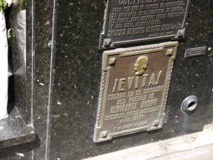 a wall with the names and date plaque of a memorial in a foreign language