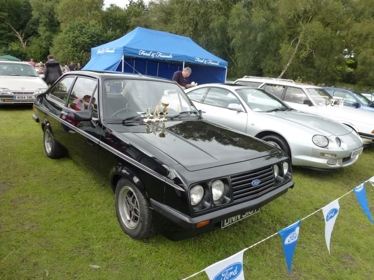 a vintage ford capri at an outdoor gathering