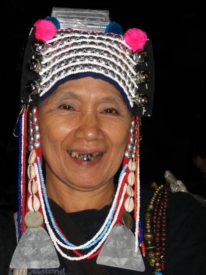 a smiling person with many beads on their head