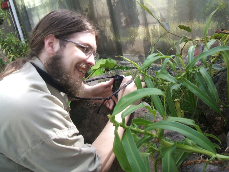 a man taking pictures with his camera in a plant