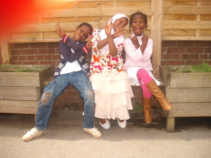 three girls and a boy sitting on a bench