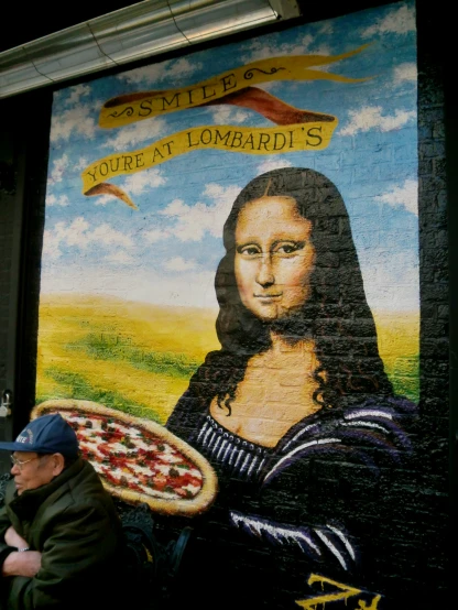 a picture of a painting on the side of a wall with a pizza next to it