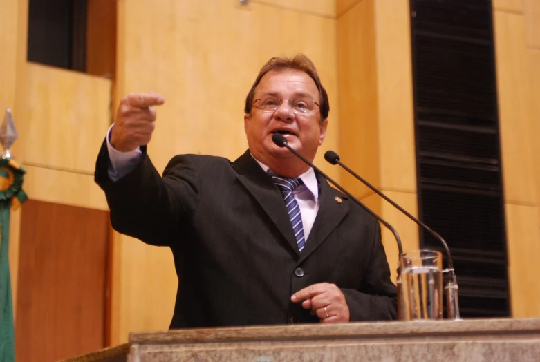 a man giving a speech while holding a microphone