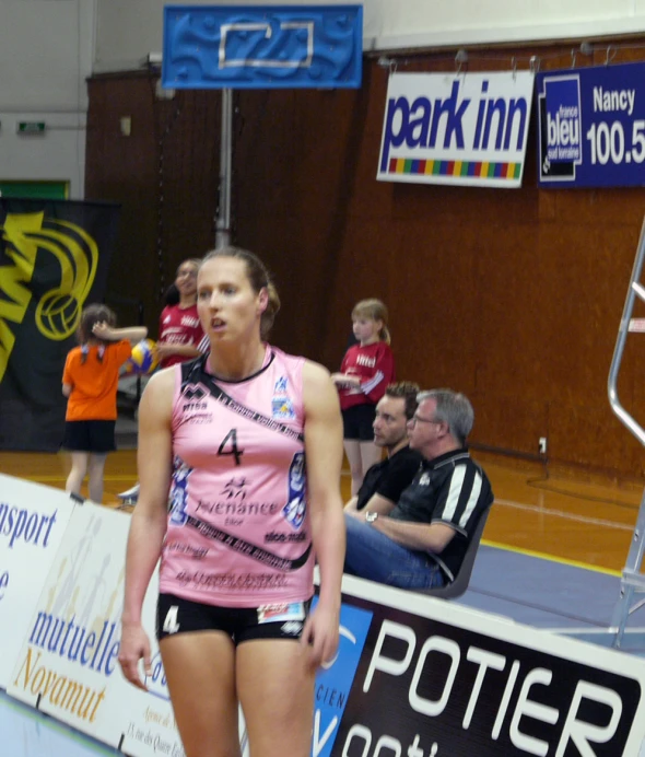 a female volleyball player is standing on the court