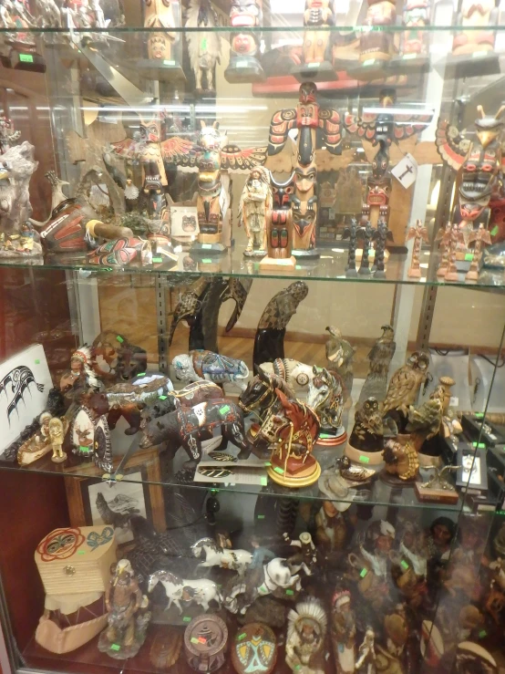 a glass display case filled with lots of different types of ceramic figurines