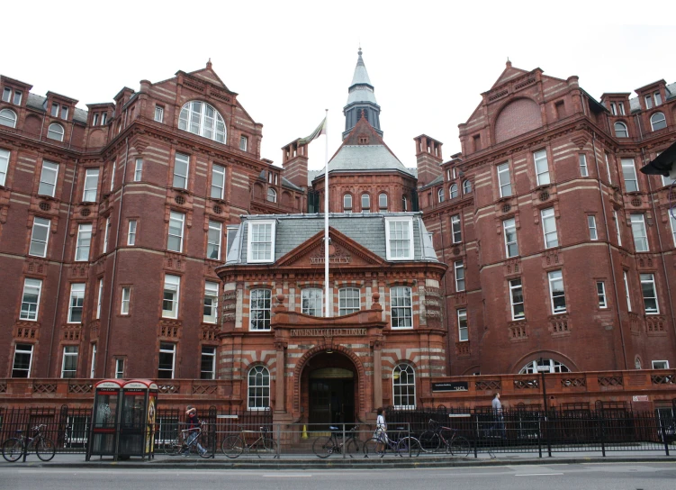 people riding bikes in front of an old building