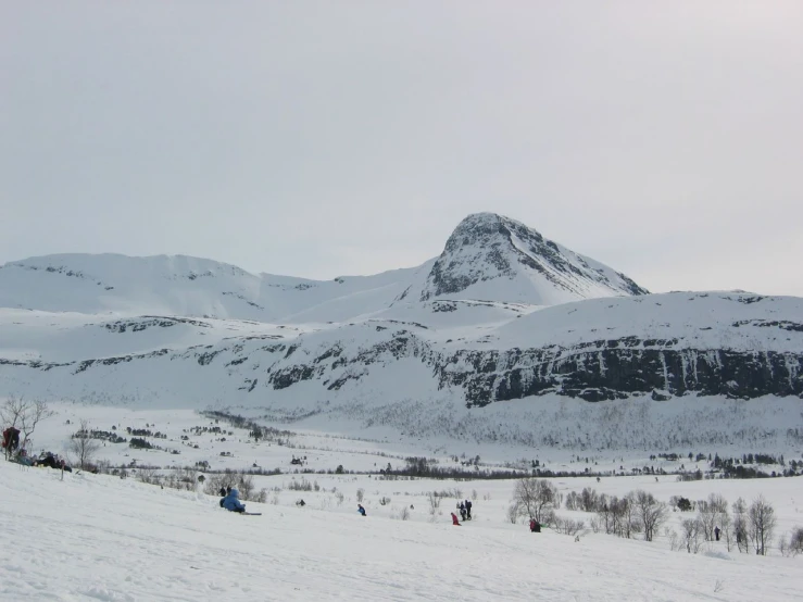 a hill covered in snow covered with mountains