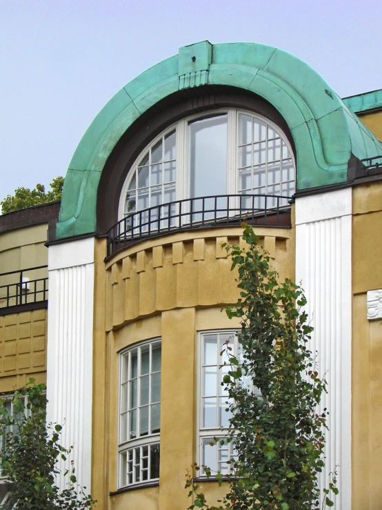 a multi - story building with round windows and green roof