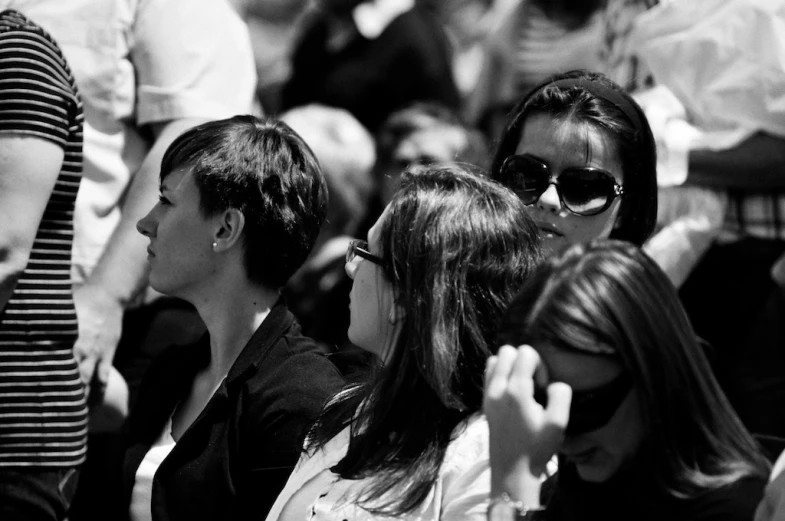 a group of people sitting and standing in a crowd