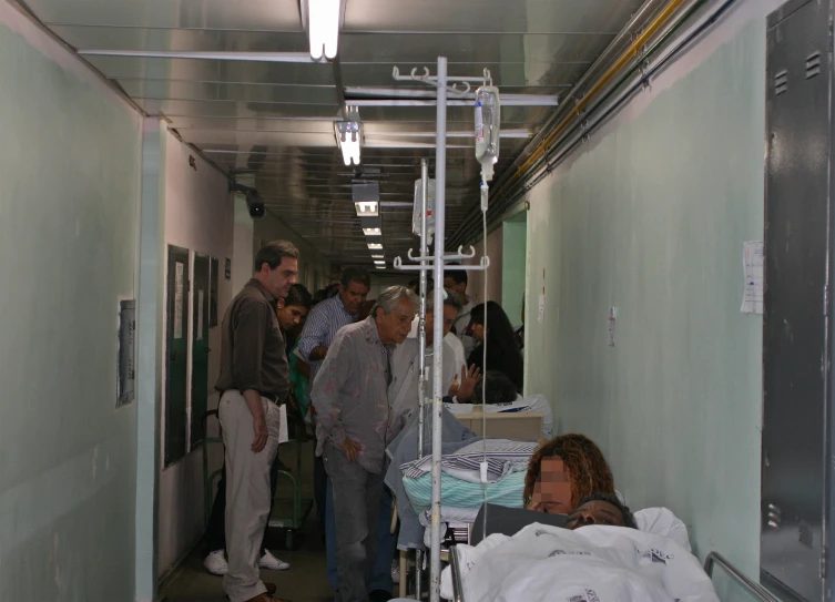 several people are walking through a hospital hallway