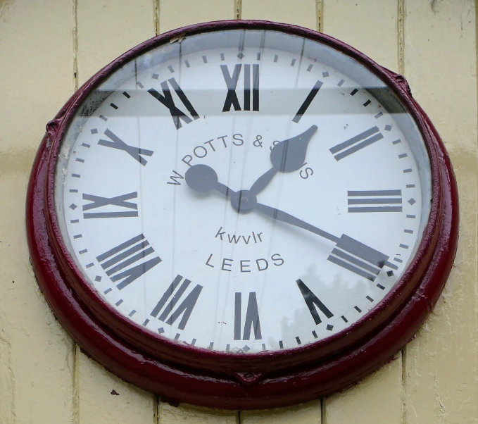 a red clock on the outside of a building reads 4 23