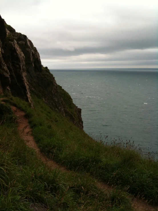 a trail leading down to the water at the edge of a cliff