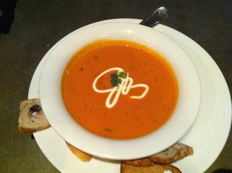 a bowl of tomato soup and some bread