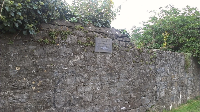 a stone wall and a street sign with an interesting design