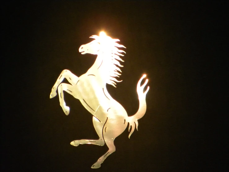 a light sculpture of a running horse against a dark night sky