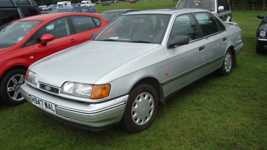 a silver and red parked cars in grass