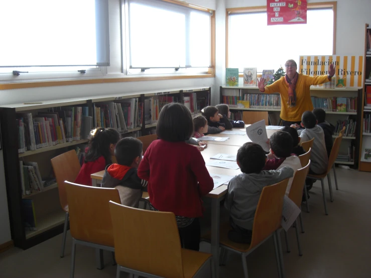 a lady reads to children in the liry