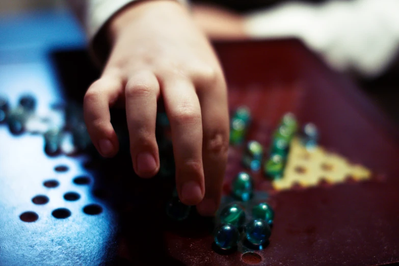 a person is touching some plastic beads on a table