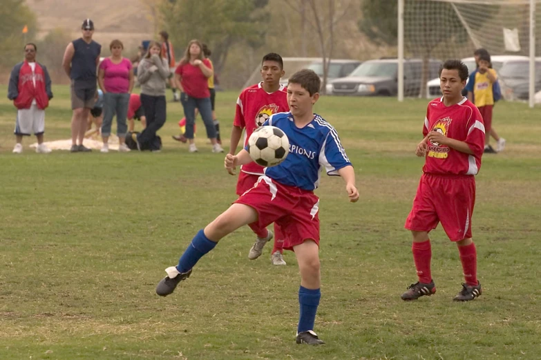 a group of young men playing soccer on top of a field