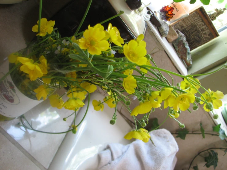 a vase of flowers sitting on top of a sink