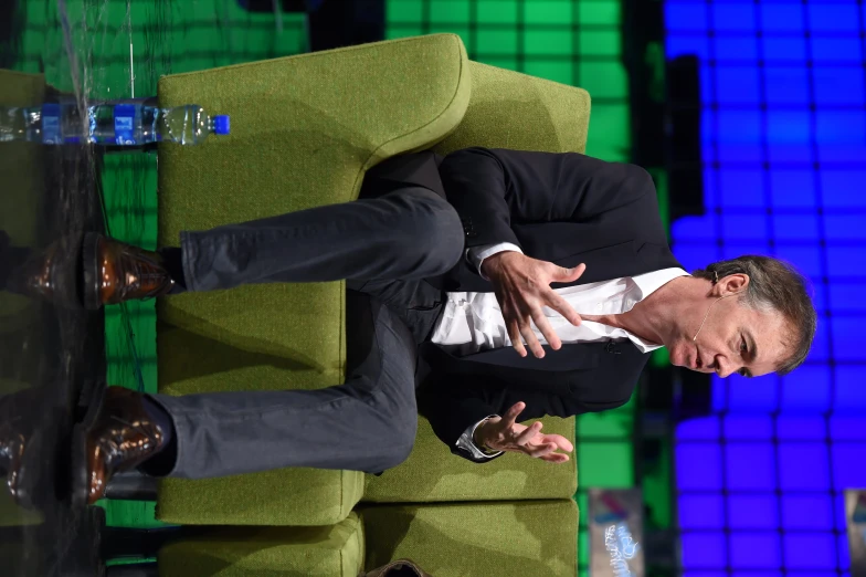 two men sitting on couches with one talking