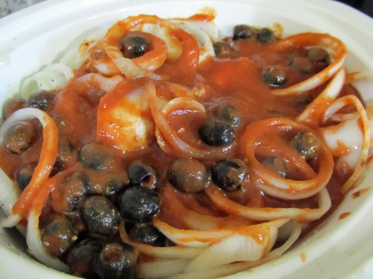 a bowl of onions and tomatoes covered in marina sauce