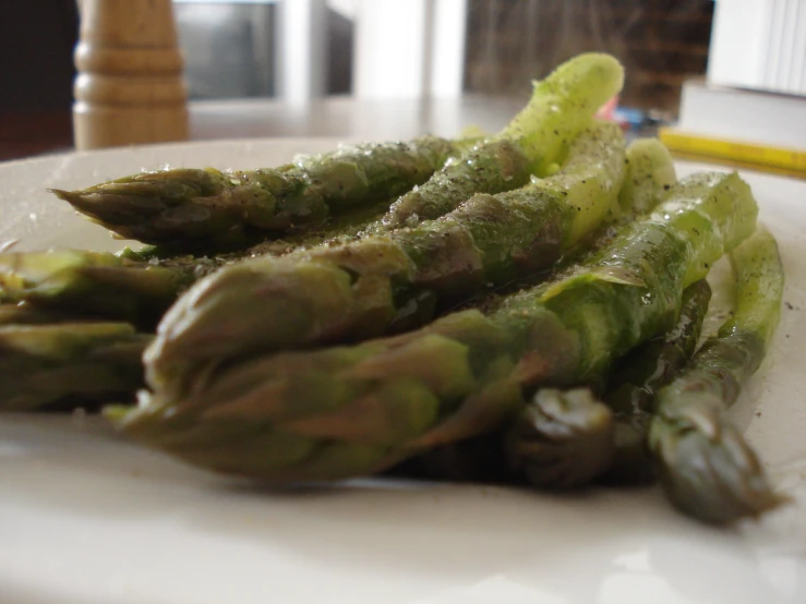 asparagus on a white plate with some powdered sugar