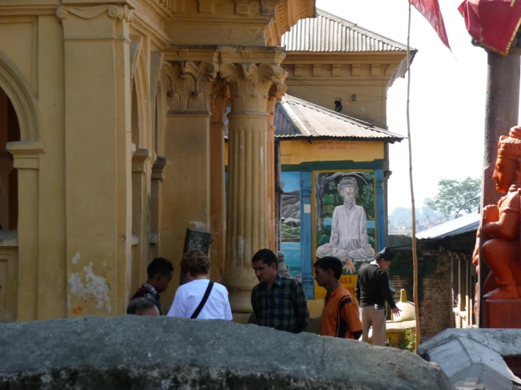 there are people standing outside of a shrine