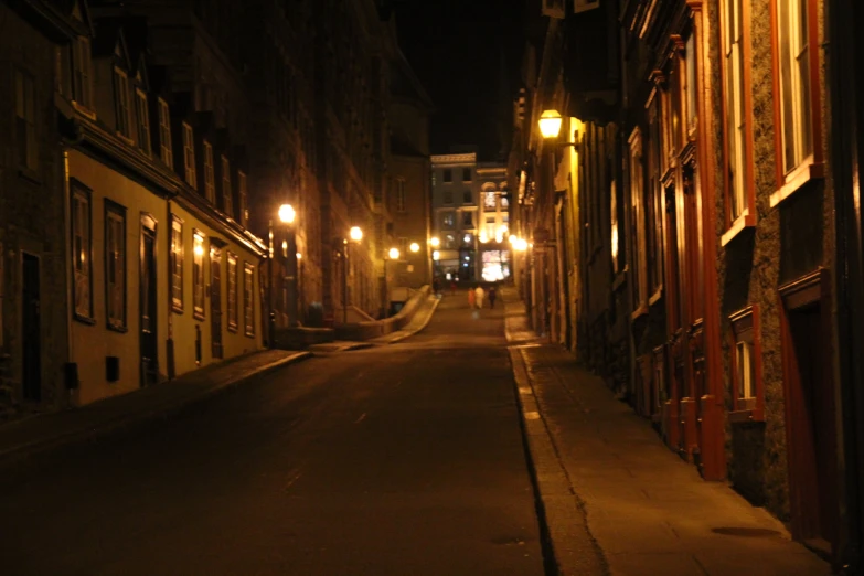 a narrow street with some lights at night