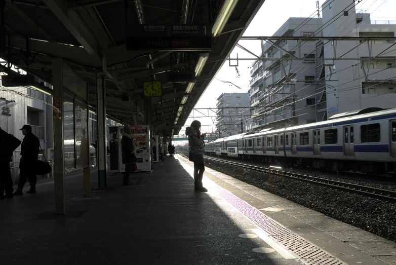 a train pulls into a train station with people waiting