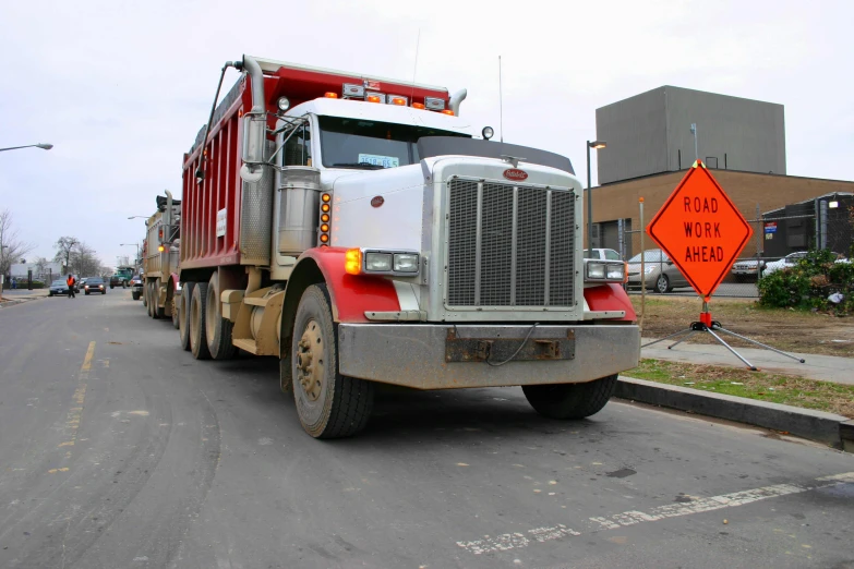 a truck driving down a street next to a tall building