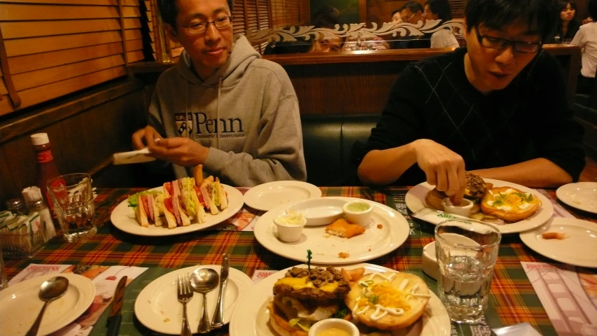 two people eating food at a restaurant table