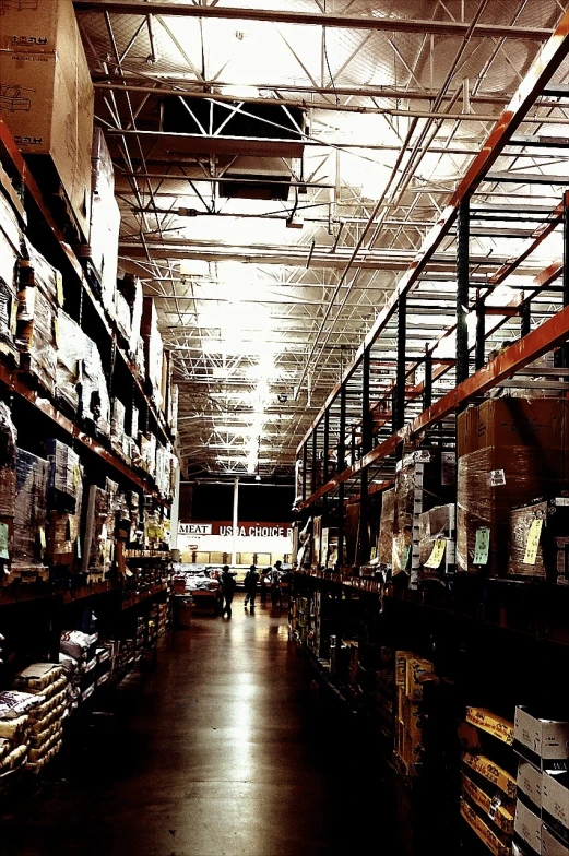 an empty and very long warehouse with some boxes