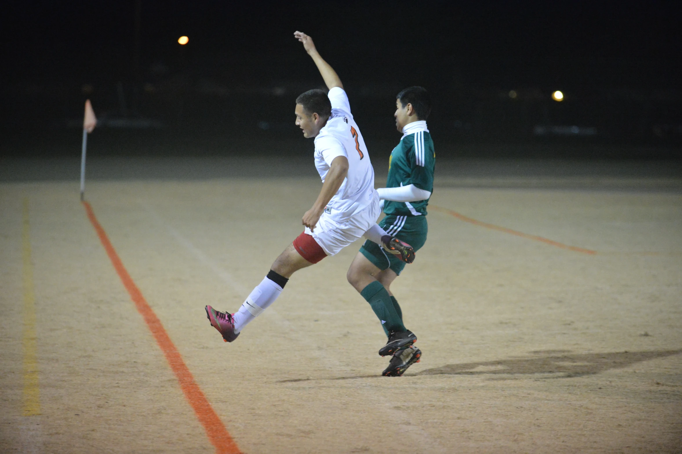 two men running across an area with soccer balls in their hands