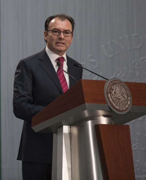 a man stands at a podium behind a microphone