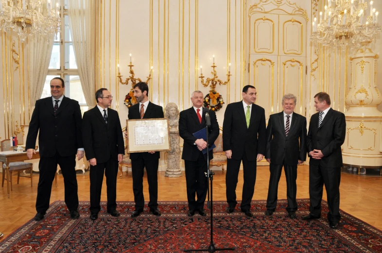 a group of men standing next to each other near a microphone