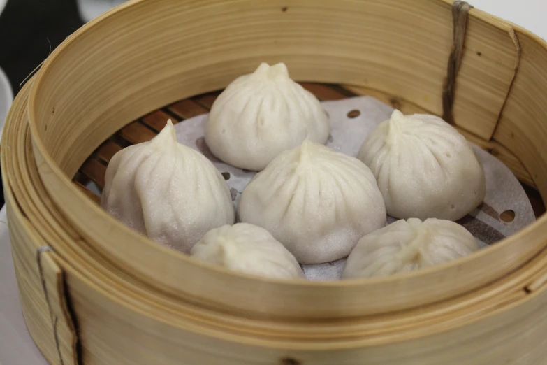 dumplings in a bamboo container filled with boiling water