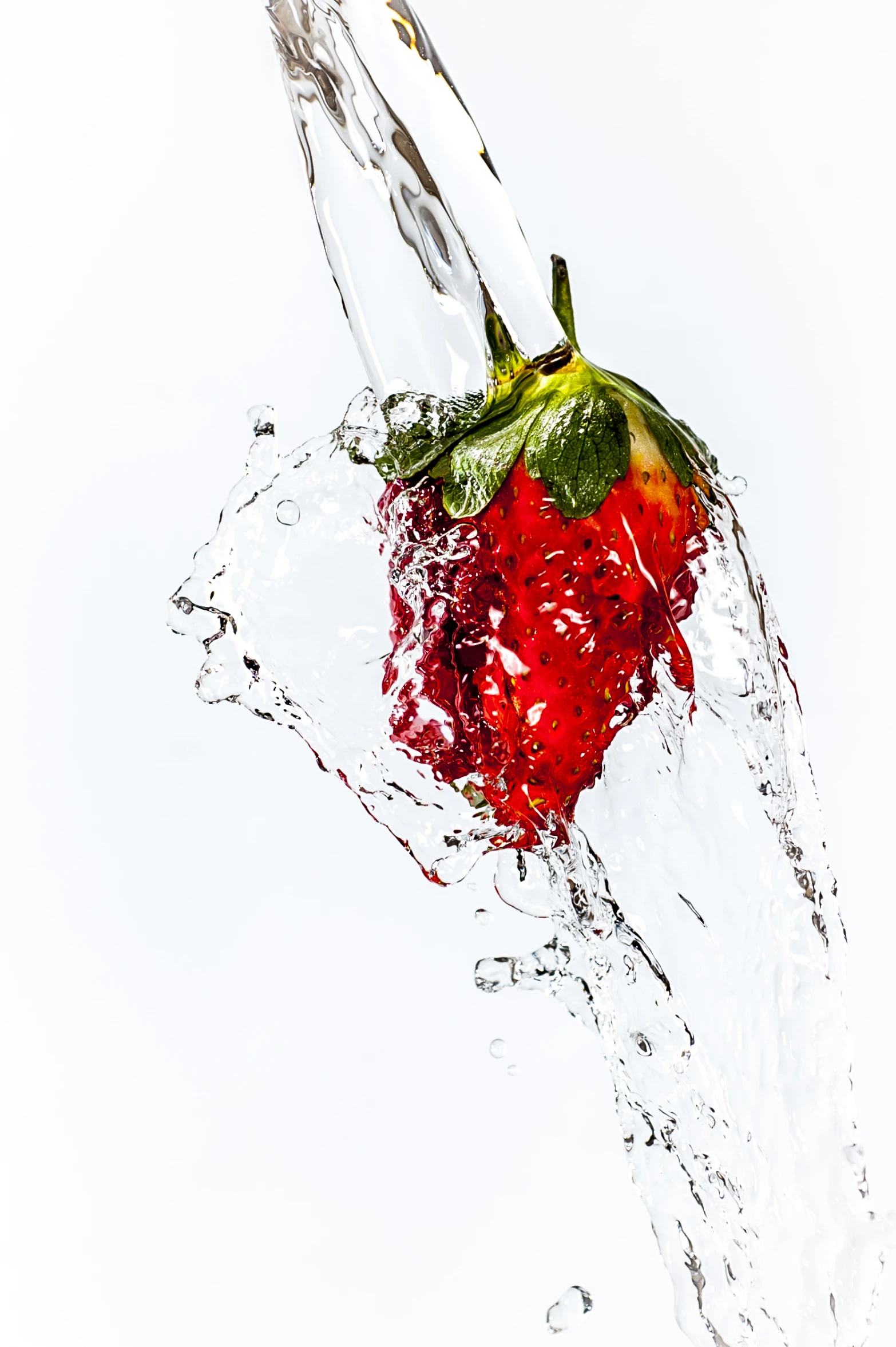 a very close s of strawberries splashing into water