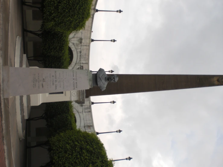 a statue in front of a tall obelisk