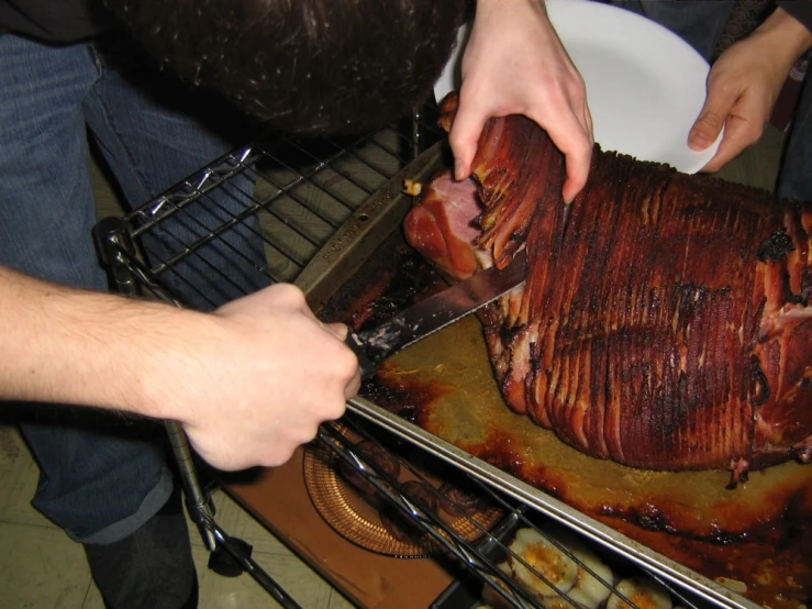 a person cuts up an enormous meat on a rack