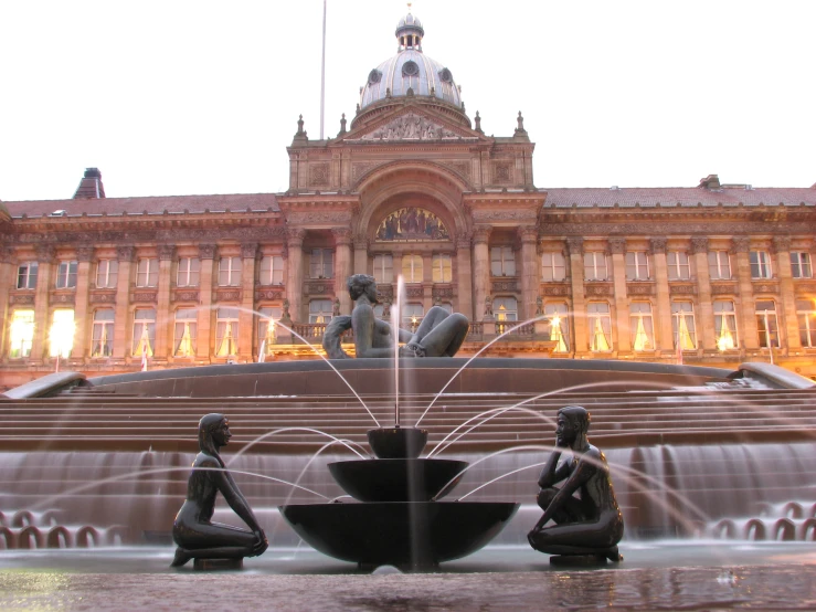 water fountains with statues sitting in front of a building