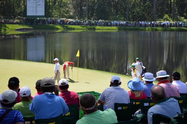 a group of people watching two men playing golf