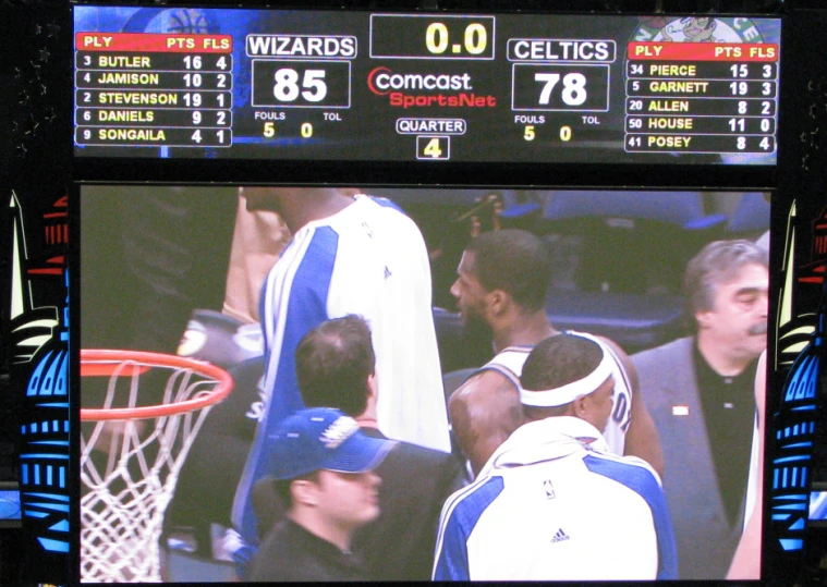 a man standing in front of a scoreboard with a game in it