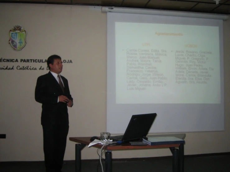 man wearing a suit giving a presentation to a class