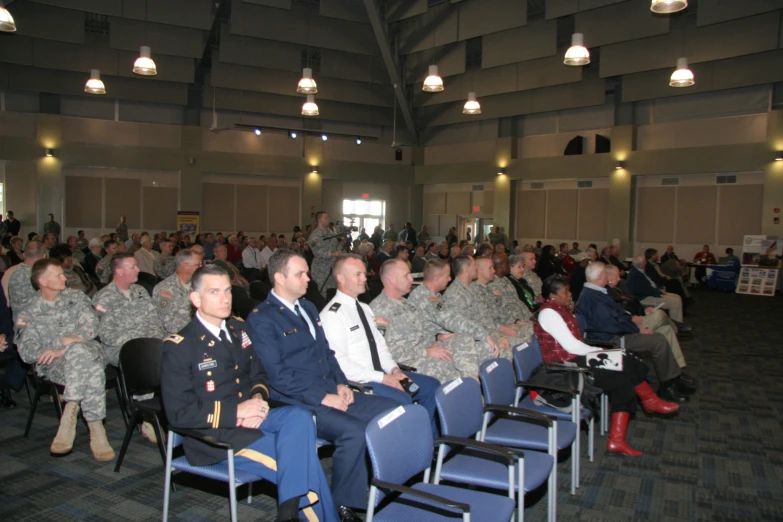 men in military suits are sitting in rows of chairs