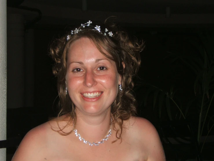 a woman wearing a tiara in a dark room