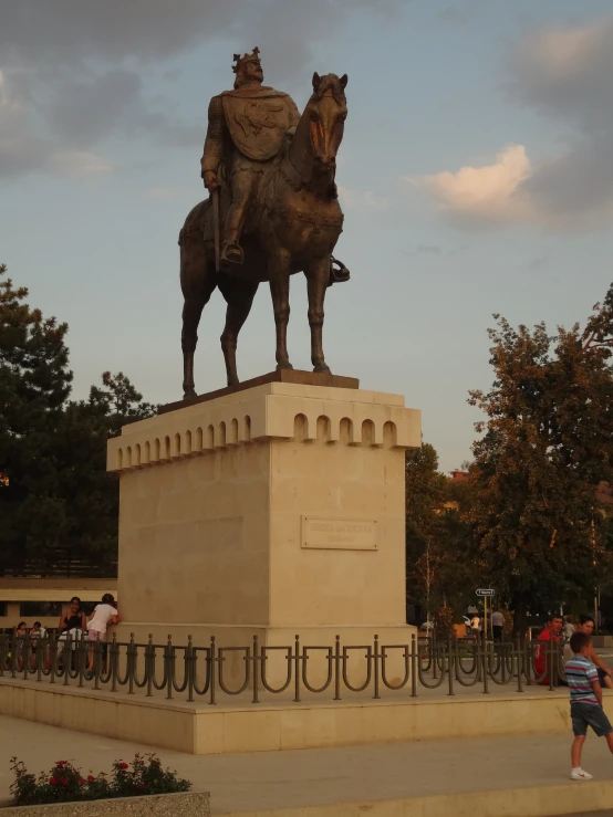 people standing around and riding on a horse statue