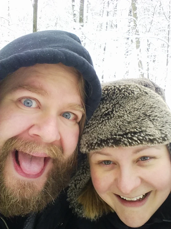 the couple smile and show their teeth while posing for the camera